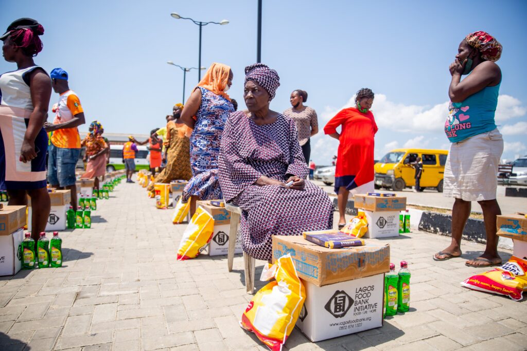 Women Outdoors with Food and Home Essentials Aid Packages